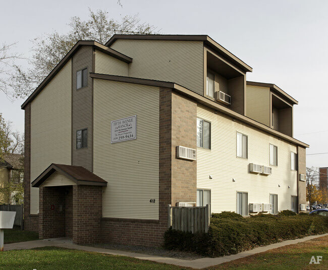 Multi-story apartment building exterior with beige siding
